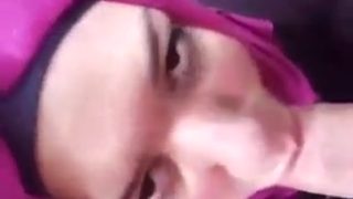 Perempuan berhijab merah jambu menjilat batang